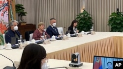 2022年5月24日，联合国人权事务高级专员巴切莱特（左二）在广州与中国公安部副部长杜航伟（右边电脑屏幕上）举行视频会议。（照片由联合国人权高专办通过美联社向外界发布。）