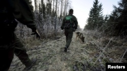 FILE - Finnish border guards patrol at the border between Finland and Russia, Nov. 3, 2009.