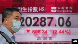 A man walks past a bank's electronic board showing the Hong Kong share index in Hong Kong, May 6, 2022. 