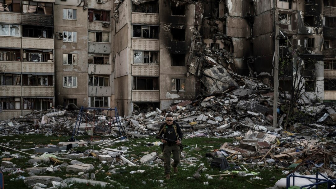 Seorang prajurit Ukraina berjalan di tengah puing-puing sebuah bangunan yang rusak berat oleh beberapa pemboman Rusia di dekat garis depan di Kharkiv, Ukraina, 25 April 2022. (Foto: AP)