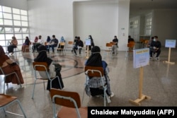 Mahasiswa duduk terpisah untuk menjaga jarak sosial di tengah kekhawatiran COVID-19, sebelum mengikuti ujian perguruan tinggi di Banda Aceh pada 5 Juli 2020. (Foto: AFP/Chaideer Mahyuddin)