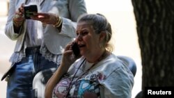 Una mujer habla por teléfono fuera del Centro Cívico Ssgt Willie de Leon, donde los estudiantes habían sido transportados desde la Escuela Primaria Robb para ser recogidos después de un tiroteo, en Uvalde, Texas, el 24 de mayo de 2022.