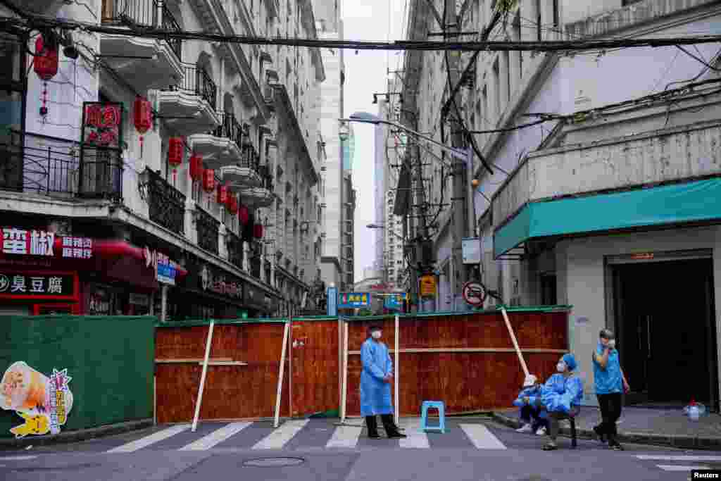 Workers in protective suits are pictured at a residential area during lockdown, amid the COVID-19)outbreak, in Shanghai, China.