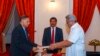 In this handout photograph provided by the Sri Lankan President's Office, President Gotabaya Rajapaksa, right, hands over the appointment document to Gamini Lakshman Peiris after he took oath of office as the new foreign minister in Colombo, Sri Lanka, Ma