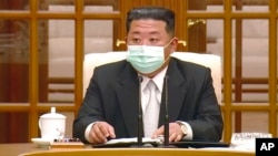 In this image made from video broadcast by North Korea's KRT, North Korean leader Kim Jong Un wears a face mask on state television during a meeting acknowledging the country's first case of COVID-19, May 12, 2022, in Pyongyang, North Korea.