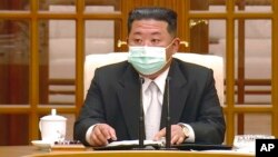 In this image made from video broadcast by North Korea's KRT, North Korean leader Kim Jong Un wears a face mask on state television during a meeting acknowledging the country's first case of COVID-19, May 12, 2022, in Pyongyang, North Korea.