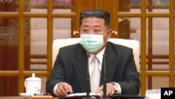 In this image made from video broadcast by North Korea's KRT, North Korean leader Kim Jong Un wears a face mask on state television during a meeting acknowledging the country's first case of COVID-19, May 12, 2022, in Pyongyang, North Korea.