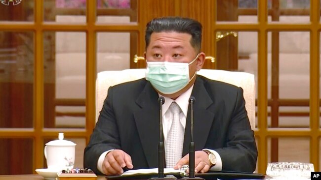 In this image made from video broadcast by North Korea's KRT, North Korean leader Kim Jong Un wears a face mask on state television during a meeting acknowledging the country's first case of COVID-19, May 12, 2022, in Pyongyang, North Korea.