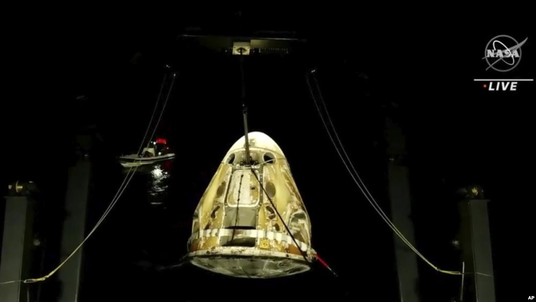 En esta imagen hecha a partir de un video proporcionado por la NASA, la cápsula espacial SpaceX Dragon sale del agua después de caer en el Golfo de México la madrugada del viernes 6 de mayo de 2022. (NASA vía AP)