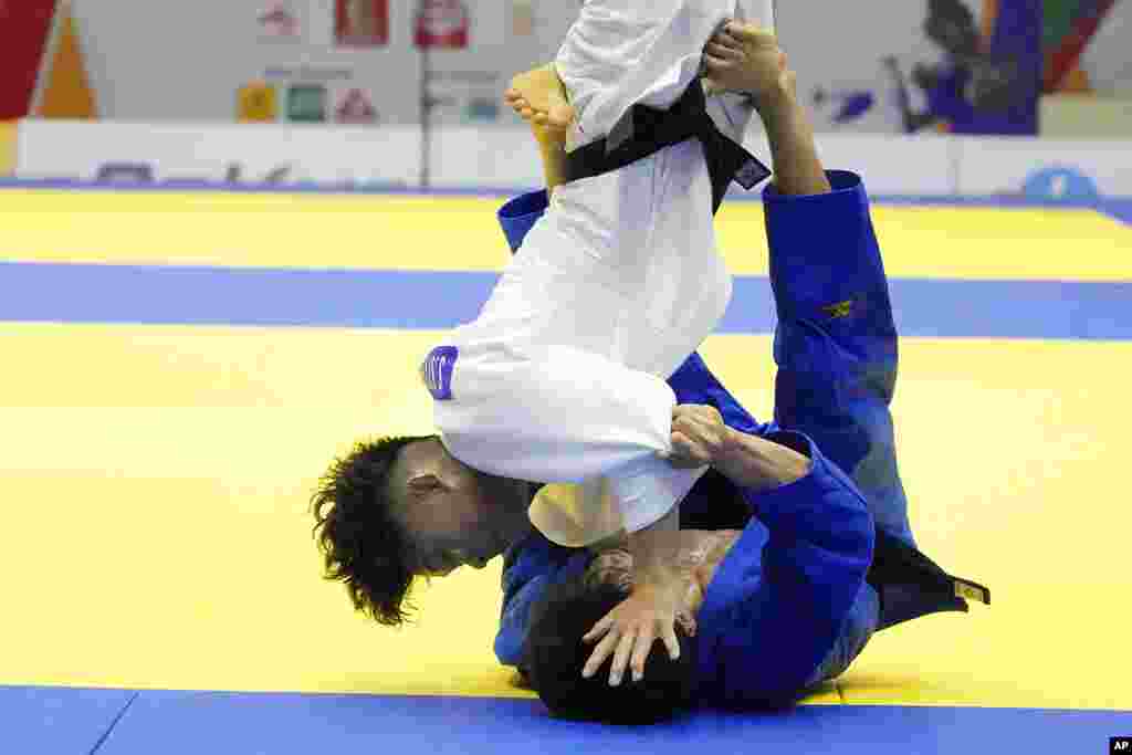 Sithisanen Soukphaxay of Laos, top, competes with Chu Duc Dat of Vietnam at the men's -60 kg judo final match during the 31st Southeast Asian Games (SEA Games 31) in Hanoi, Vietnam.