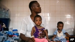 FILE- In this April 15, 2022 file photo, malnourished children wait for treatment in the pediatric department of Boulmiougou hospital in Ouagadougou, Burkina Faso. The U.N. is warning that 18 million people in Africa’s Sahel region face severe hunger in the next three months. 