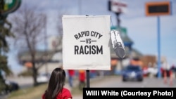 Native American woman participating in NDN Collective protest against racist businesses in Rapid City, S.D., April 20, 2022. 