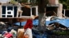 A civilian walks by a destroyed building in Mariupol, territory controlled by the government of the Donetsk People's Republic, in eastern Ukraine, on May 27, 2022.