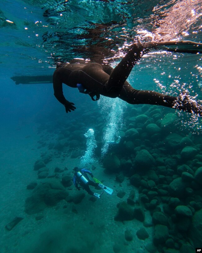 This photo provided by Clean Up The Lake shows scuba divers during the 72 Mile Clean Up during the winter of 2022, in Lake Tahoe, Nev.