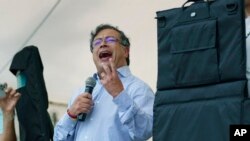 FILE - Flanked by bulletproof shields, presidential candidate Gustavo Petro of the Historical Pact coalition speaks at a campaign rally in Fusagasuga, Colombia, May 11, 2022.
