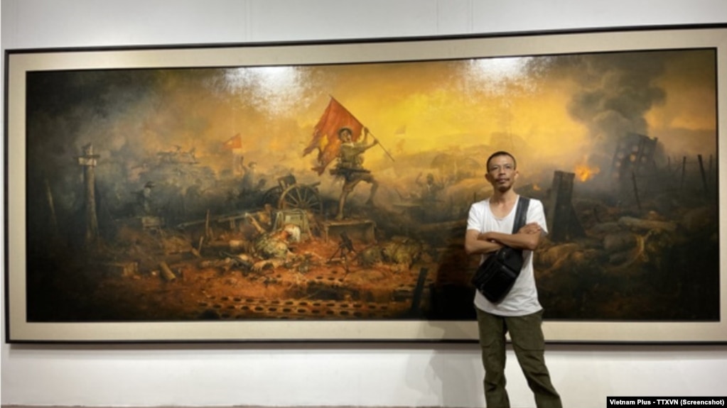 Họa sỹ Mai Duy Minh bên bức tranh "Điện Biên Phủ", tác phẩm chính trong triển lãm hội họa bị ngừng ngay trước giờ khai mạc hôm 7/5 tại Đại học Mỹ thuật ở Hà Nội.