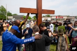 A group prays at a memorial for the victims of the Buffalo supermarket shooting outside the Tops Friendly Market, in Buffalo, N.Y., May 22, 2022.