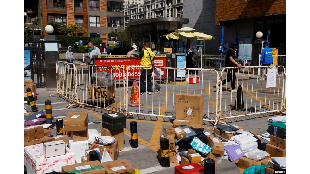 Couriers make deliveries outside a residential compound under lockdown, amid the coronavirus disease (COVID-19) outbreak, in Beijing, China May 2, 2022.