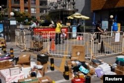 Couriers make deliveries outside a residential compound under lockdown, amid the coronavirus disease (COVID-19) outbreak, in Beijing, China May 2, 2022.