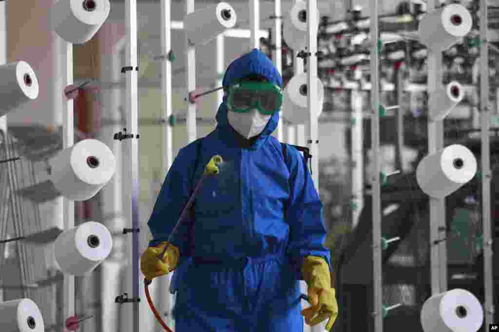 An employee of Songyo Knitwear Factory in Songyo district disinfects the work floor in Pyongyang, North Korea.