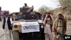FILE - Armed militants of Tehrik-e-Taliban Pakistan (TTP) are pictured next to a captured armored vehicle in the Pakistan-Afghanistan border town of Landikotal on Nov. 10, 2008, after they hijacked supply trucks bound for Afghanistan.