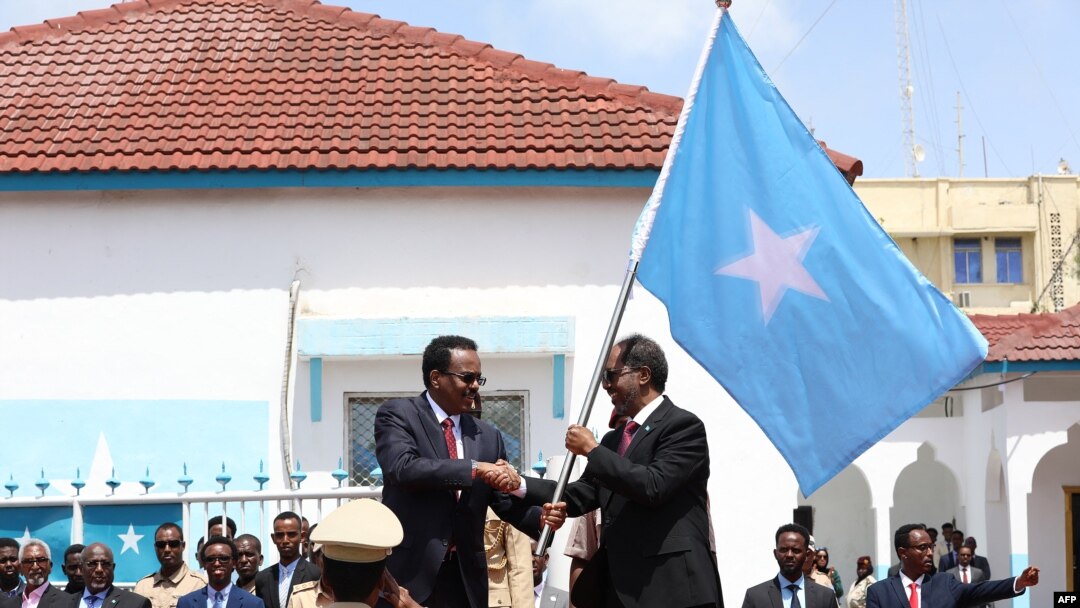 Perezida ahejeje amabanga yiwe, Mohamed Abdullahi Mohamed, ibubamfu, ahereza ibendera ry'igihugu uwuheruka gutorwa Hassan Sheikh Mohamud. 