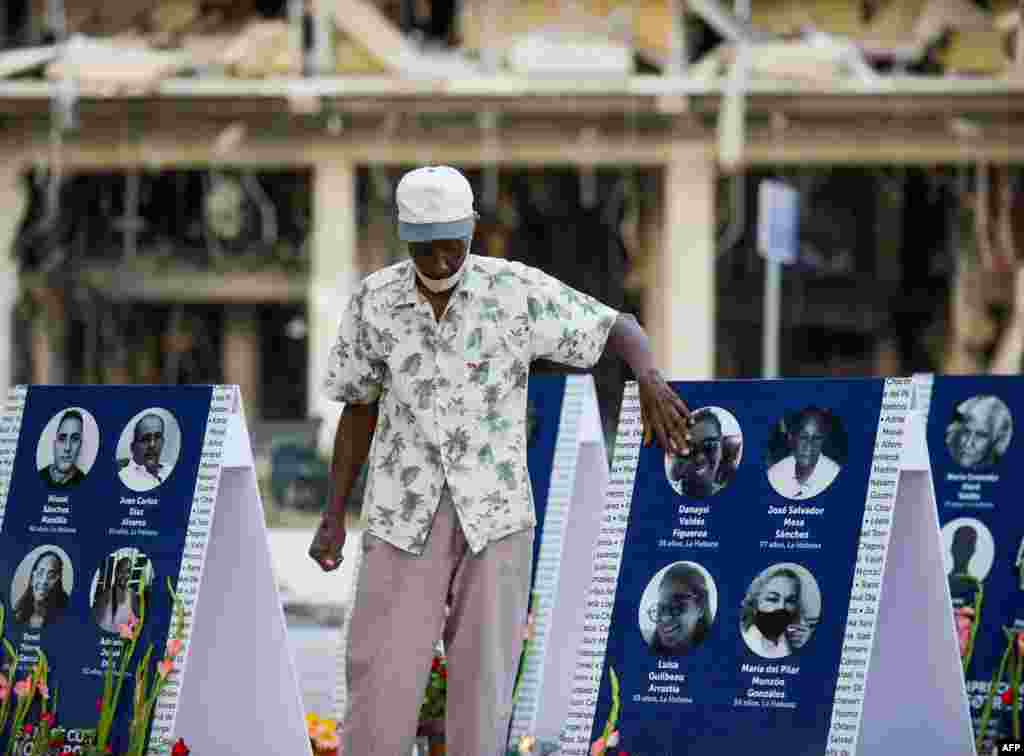 Un familiar de una víctima del accidente del Hotel Saratoga toca una imagen de su familiar amado durante una vigilia en La Habana, el 13 de mayo de 2022.