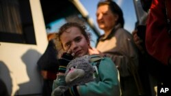 A child and her family who fled from Mariupol arrive at a reception center for displaced people in Zaporizhzhia, Ukraine, May 8, 2022. 