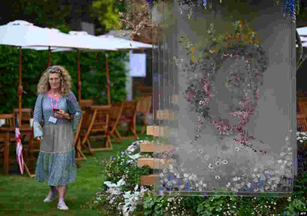 An image of Britain&#39;s Queen Elizabeth II, ahead of her Platinum Jubliee event, is shown at the Veevers Carter garden during the 2022 RHS Chelsea Flower Show in London. (Photo by Daniel LEAL / AFP)