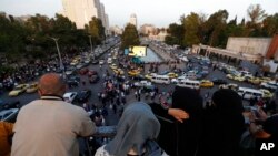 Dozens of Syrians wait at the President's Bridge in Damascus for relatives they hope would be among those released from prison on May 3, 2022.