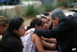 Uskup Agung San Antonio, Gustavo Garcia-Siller, menghibur keluarga di luar Civic Center menyusul penembakan mematikan di Sekolah Dasar Robb di Uvalde, Texas, Selasa, 24 Mei 2022. (Foto: AP)