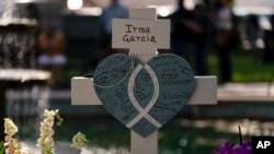 Messages are written on a cross honoring Irma Garcia, a teacher who was killed in the elementary school shooting in Uvalde, Texas, May 26, 2022.