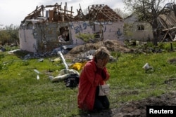 Tetyana Pochivalova reacts outside her destroyed house in Vilhivka village amid Russia's attack on Ukraine, near Kharkiv, Ukraine, May 11, 2022.