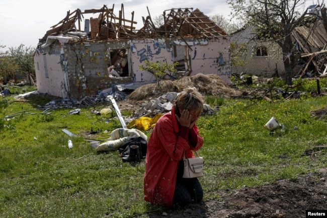 Tetyana Pochivalova reacts outside her destroyed house in Vilhivka village amid Russia's attack on Ukraine, near Kharkiv, Ukraine, May 11, 2022.
