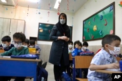 تہران میں واقع ایک اسکول کےبچوں حفاظتی بندوبست کے طور پر چہروں پر ماسک لگا رکھے ہیں۔ فائل فوٹو