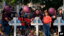 Residente del lugar de la masacre en Uvalde, Texas, se reúne en un sitio conmemorativo para presentar sus respetos a las víctimas que murieron en el tiroteo de esta semana en una escuela primaria, el 26 de mayo de 2022. 