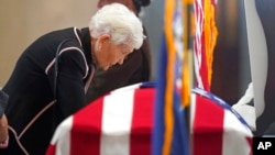 Elaine Hatch stands at the casket of husband, former US Sen. Orrin Hatch, while he lies in state at the Utah Capitol, May 4, 2022, in Salt Lake City.