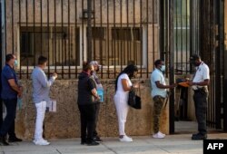 En esta foto de archivo tomada el 3 de mayo de 2022, la gente hace fila en la embajada de Estados Unidos en La Habana, mientras el consulado reanudó la emisión de algunos servicios de visas de inmigrantes que habían sido suspendidos desde 2017 tras los llamados "ataques sonicos" que impactaron la salud de los diplomáticos estadounidenses.