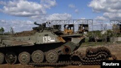 Un véhicule de combat détruit est photographié sur la route qui relie Kharkiv et un village récemment repris par l'armée ukrainienne, près de Kharkiv, Ukraine, le 13 mai 2022. (REUTERS/Ricardo Moraes)