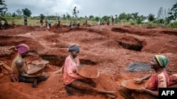 FILE: Tanzanian miners Mwagyma Ramadhan, Regina Daud and Maria Ng'ombe look for gold at an open-pit gold mine in Nyarugusu, Geita Region, Tanzania, May 27, 2022.