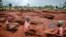 FILE: Tanzanian miners Mwagyma Ramadhan, Regina Daud and Maria Ng'ombe look for gold at an open-pit gold mine in Nyarugusu, Geita Region, Tanzania, May 27, 2022.