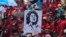Empleados del Sindicato de Trabajadores del Instituto Hondureño del Seguro Social sostienen un cartel de la líder indígena asesinada Berta Cáceres durante la manifestación del Primero de Mayo (Día del Trabajo) en San Pedro Sula, Honduras, el 1 de mayo de 2022.