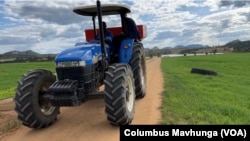 A farmer drives a tractor through a wheat farm in the Banket Zvimba district in Zimbabwe on May 4, 2022.