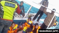 Tim penyelamat mengevakuasi beberapa korban tenggelamnya kapal feri dengan 43 penumpang di Selat Makassar. (Foto: BASARNAS via AFP)