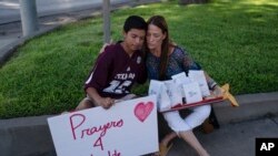 Diego Esquivel, left, and Linda Klaasson comfort one other as they honor the victims killed in Tuesday's shooting at Robb Elementary School in Uvalde, Texas, Wednesday, May 25, 2022. 