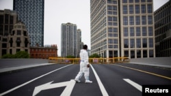A worker in a protective suit walks on a closed bridge during lockdown, amid the COVID-19 outbreak, in Shanghai, China, May 18, 2022. 