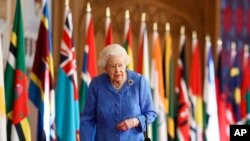 FILE - Britain's Queen Elizabeth II walks past Commonwealth flags in St. George's Hall at Windsor Castle, England, to mark Commonwealth Day in this image that was issued March 6, 2021.