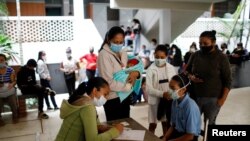 Un estudiante de una escuela pública se registra para recibir una dosis de la vacuna Sinopharm contra la enfermedad por coronavirus como parte de una campaña de vacunación para adolescentes, en Caracas, el 27 de octubre de 2021.