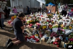 Salvatore Di Grazia, a teacher from Rio Grande Valley, Texas, visits a memorial at Robb Elementary School in Uvalde, Texas, May 30, 2022, for the victims killed in last week's school shooting. (AP Photo/Jae C. Hong)