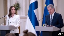 Finland's Prime Minister Sanna Marin (L) and Finland's President Sauli Niinisto give a press conference to announce that Finland will apply for NATO membership at the Presidential Palace in Helsinki, May 15, 2022. 